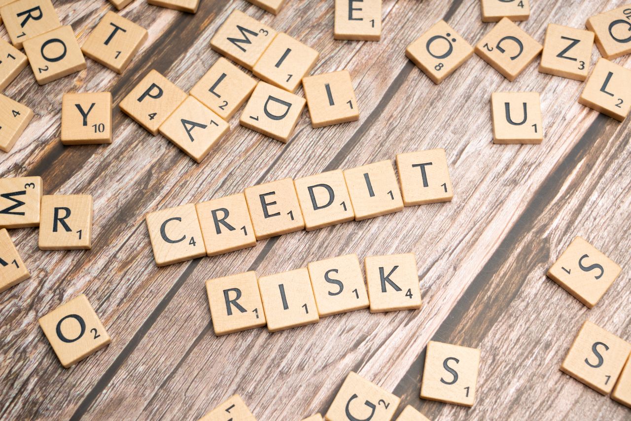 The Art of Drawing Readers In: Your attractive post title goes here Scattered wooden letter tiles spelling 'credit risk' on a rustic wooden surface.